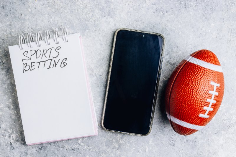 note book with text sports betting, mobile and american football